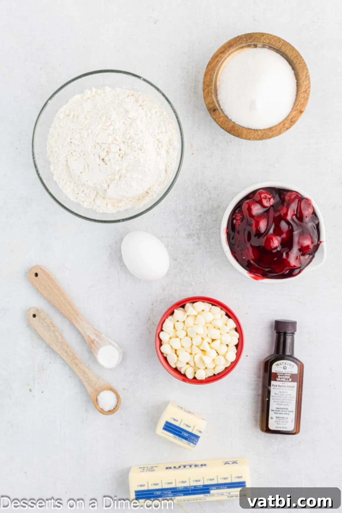 Ingredients for recipe - flour, baking powder, salt, butter, sugar, egg, vanilla, cherry pie filling, white chocolate chips.