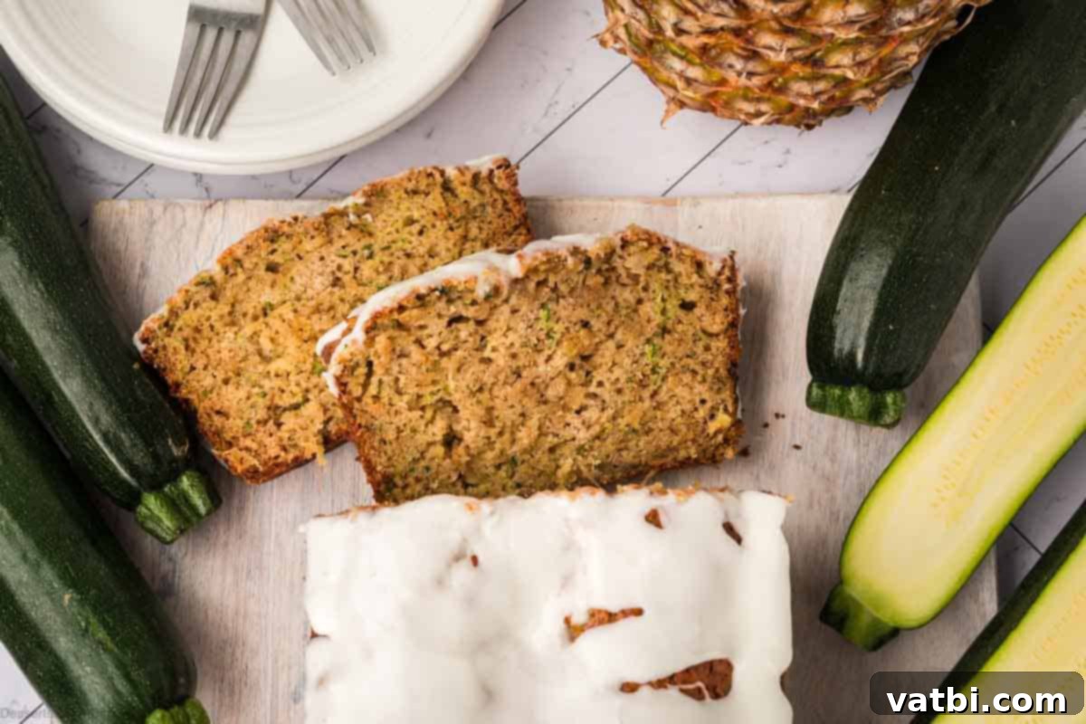 Slices of zucchini bread with pineapple next to fresh zucchini and pineapple chunks.