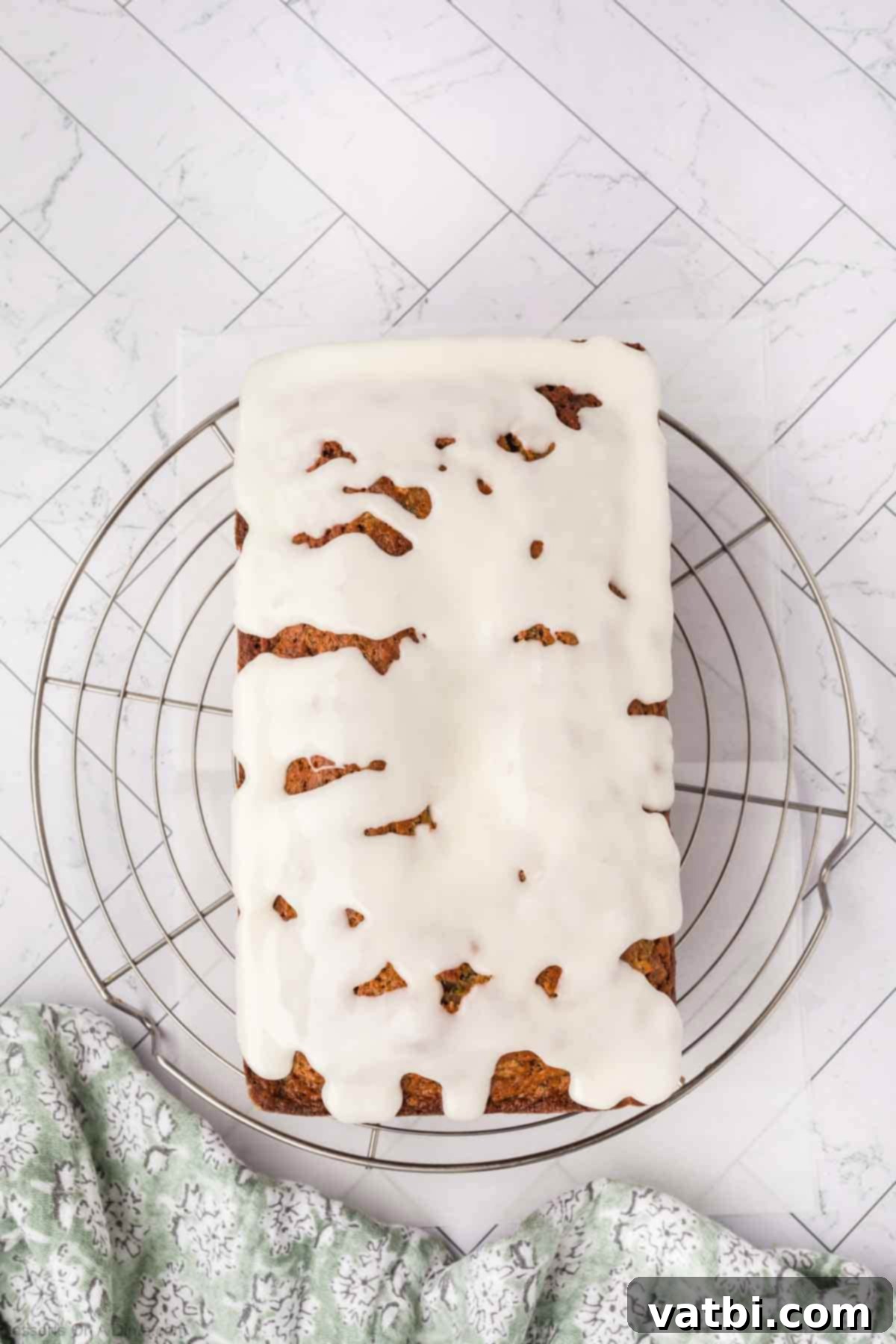 Cooled zucchini bread on a wire rack topped with a pineapple glaze.