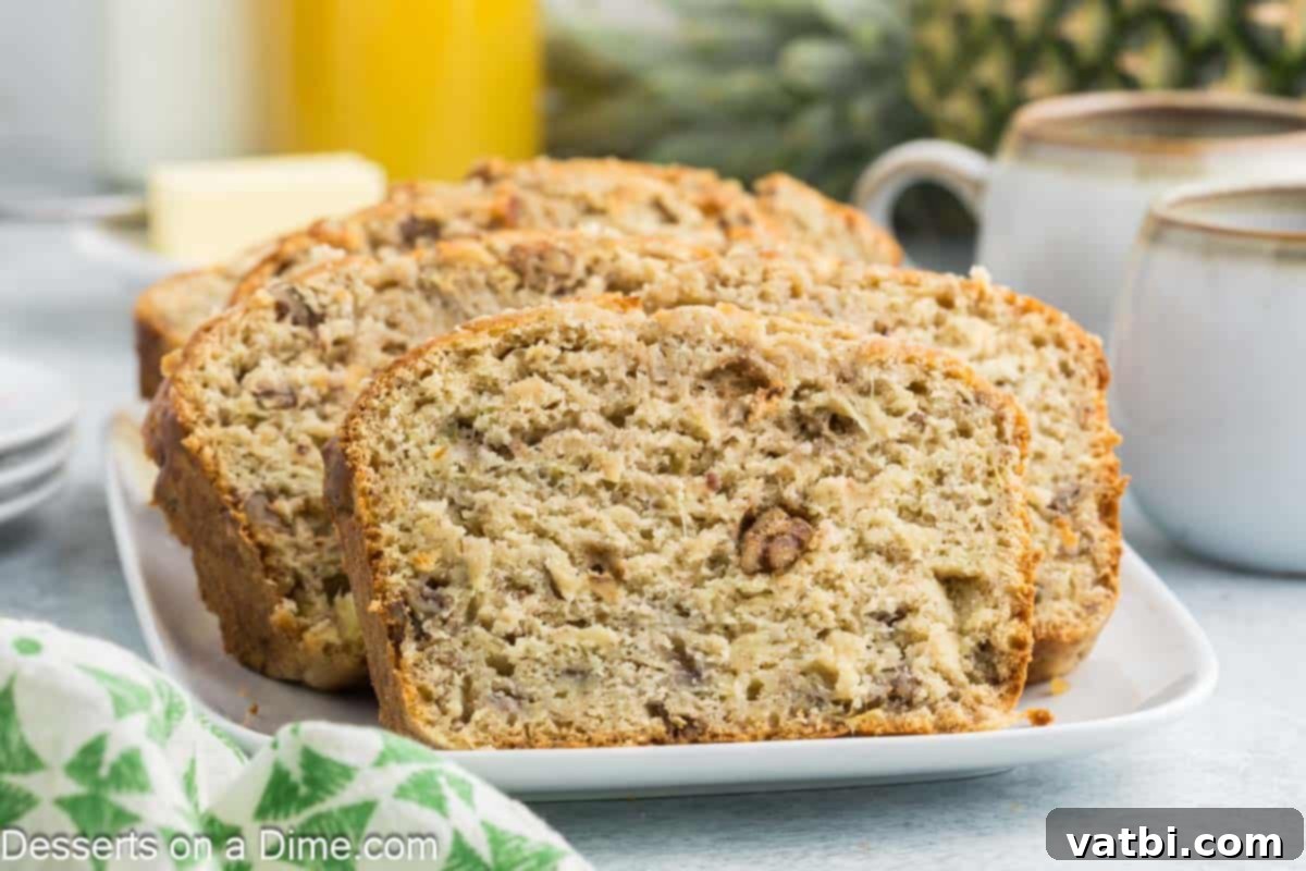 Tropical Sunshine Loaf 2 Banana Pineapple Bread sliced on a platter, showcasing its moist texture and appealing appearance.