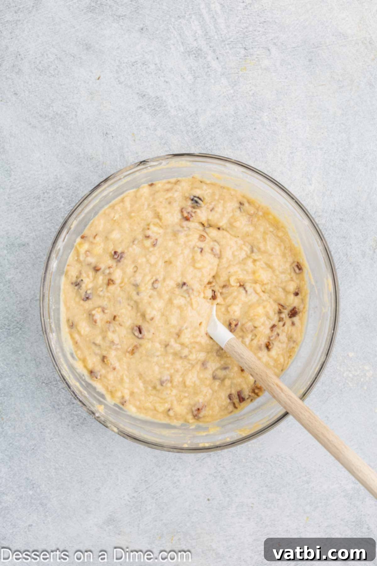 Tropical Sunshine Loaf 8 Dry ingredients being gently folded into the wet ingredients, along with chopped nuts for added texture.