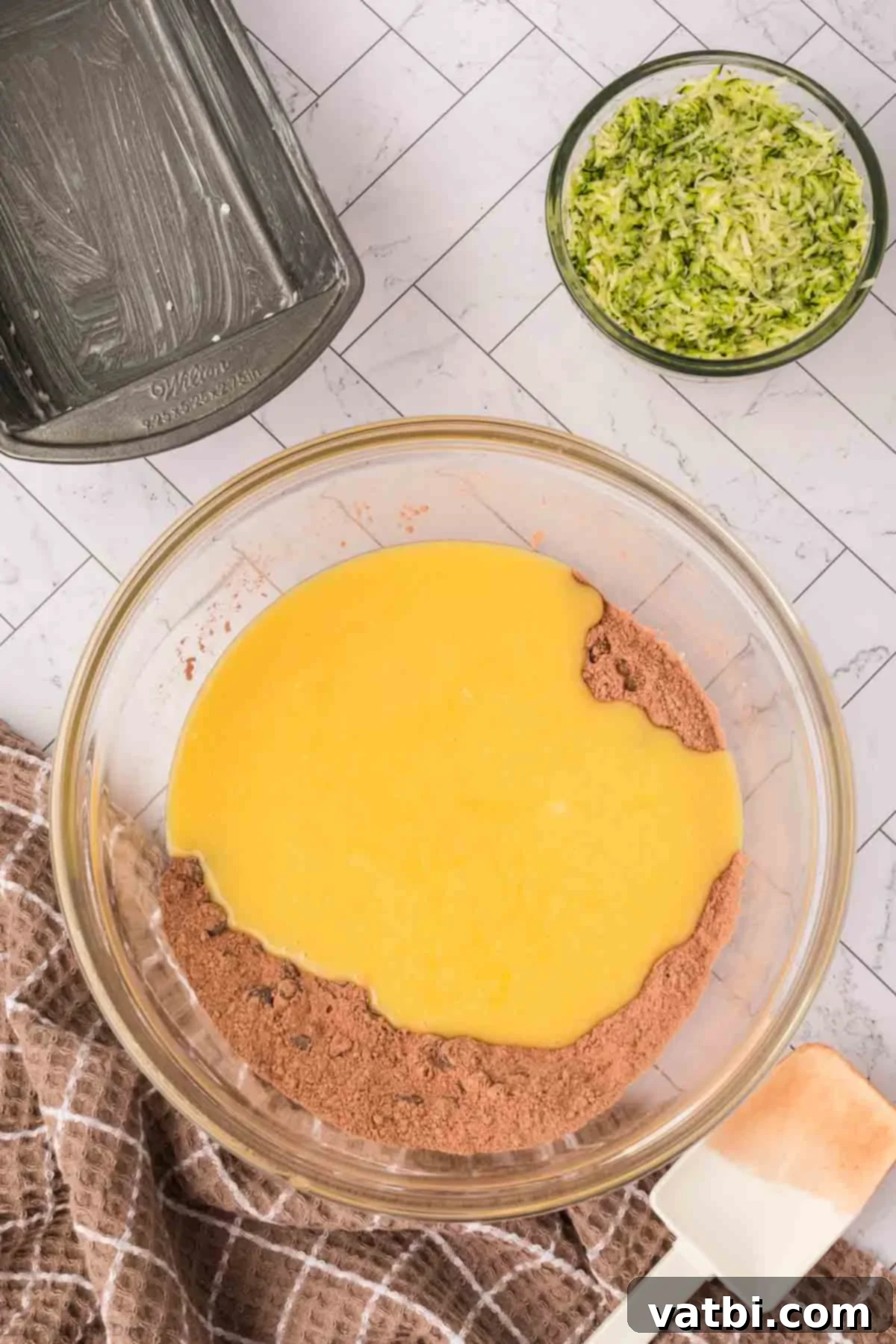 Chocolate Zucchini Bliss 8 Wet ingredients being poured into the bowl of dry ingredients.