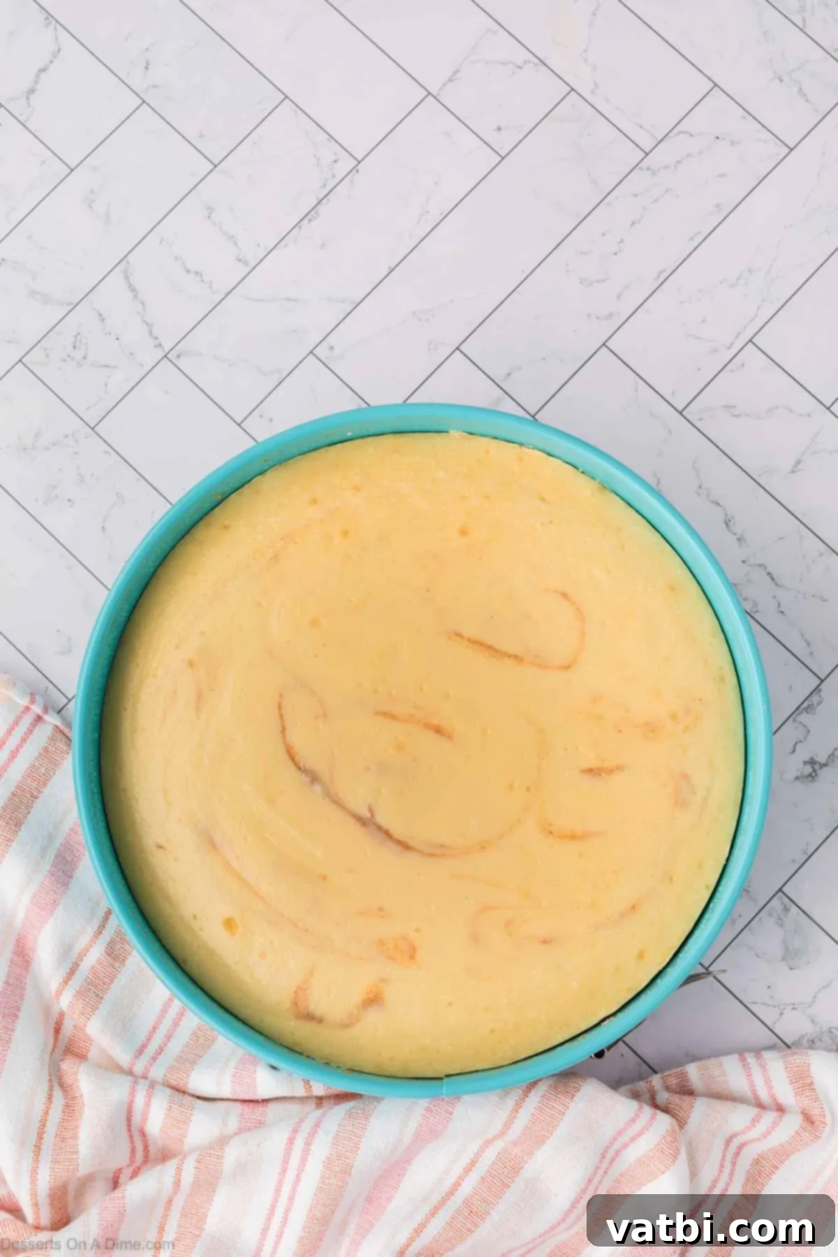 Baked cheesecake cooling on a wire rack after being removed from the water bath.