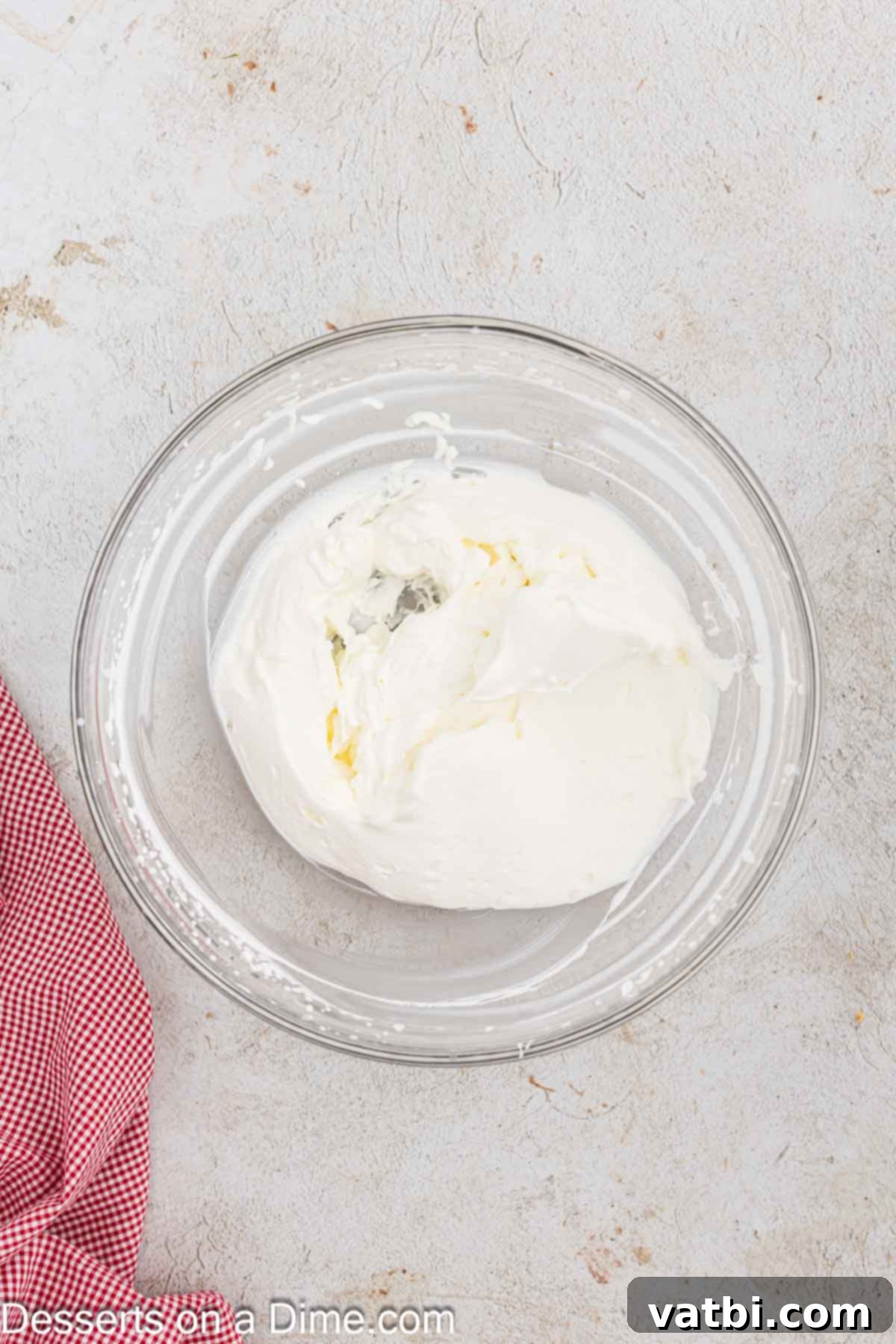 Heavy cream being whipped in a mixing bowl using an electric mixer until stiff peaks form, creating a light and airy texture.